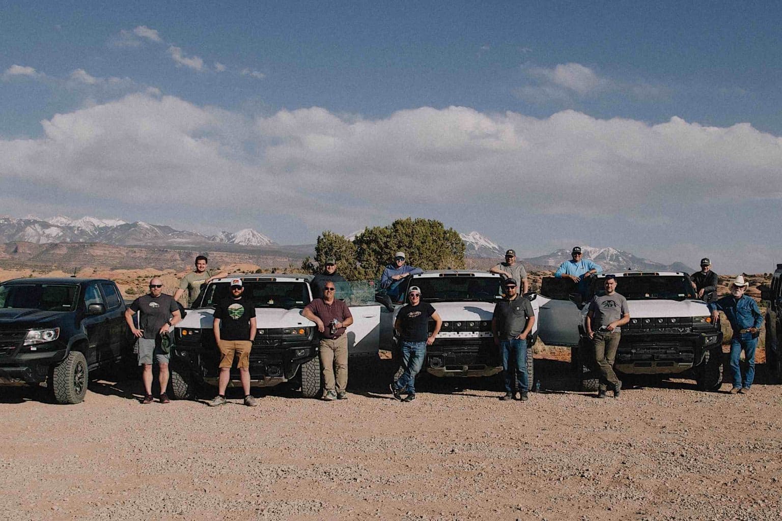 A group of people standing in front of GMC Hummers.