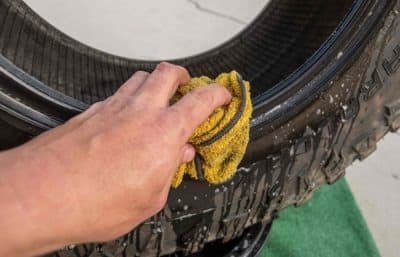A person cleaning a tire.