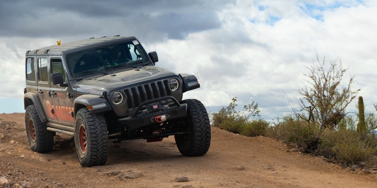 A Jeep driving across dirt terrain.