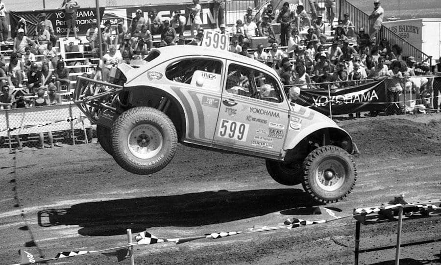 A VW Bettle with large tires racing.